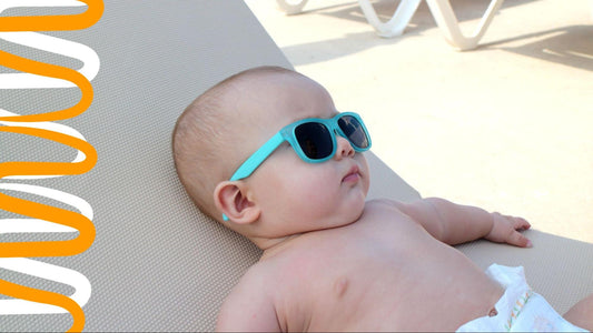 baby lying in the shade wearing blue sunglasses